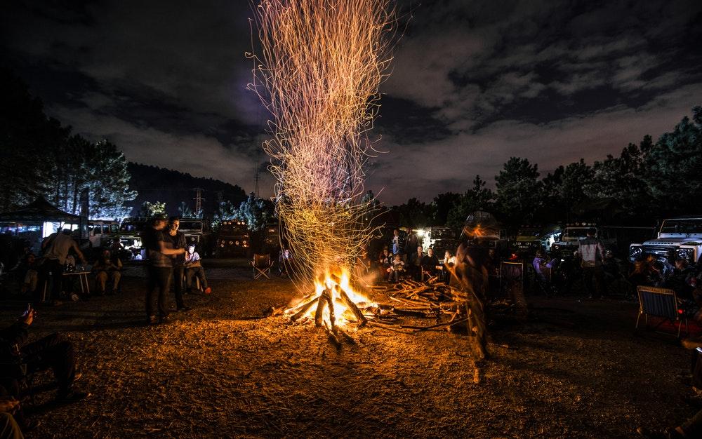 people standing next to bonfire