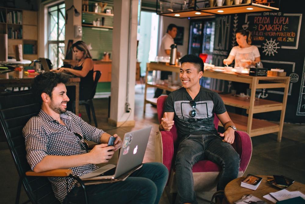 two men laughing white sitting on chairs