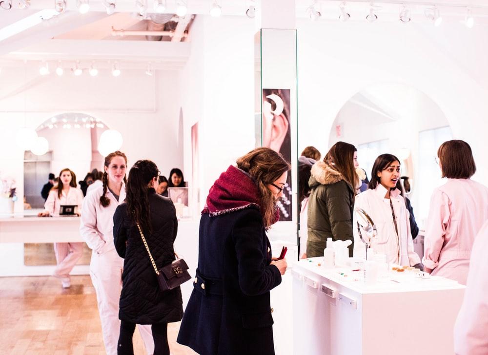 people standing near desk with makeup kits